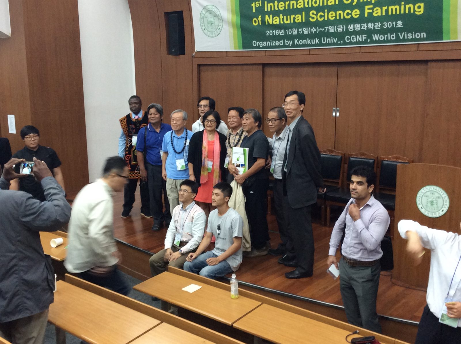 Gathering under the banner for photos after the last talk.